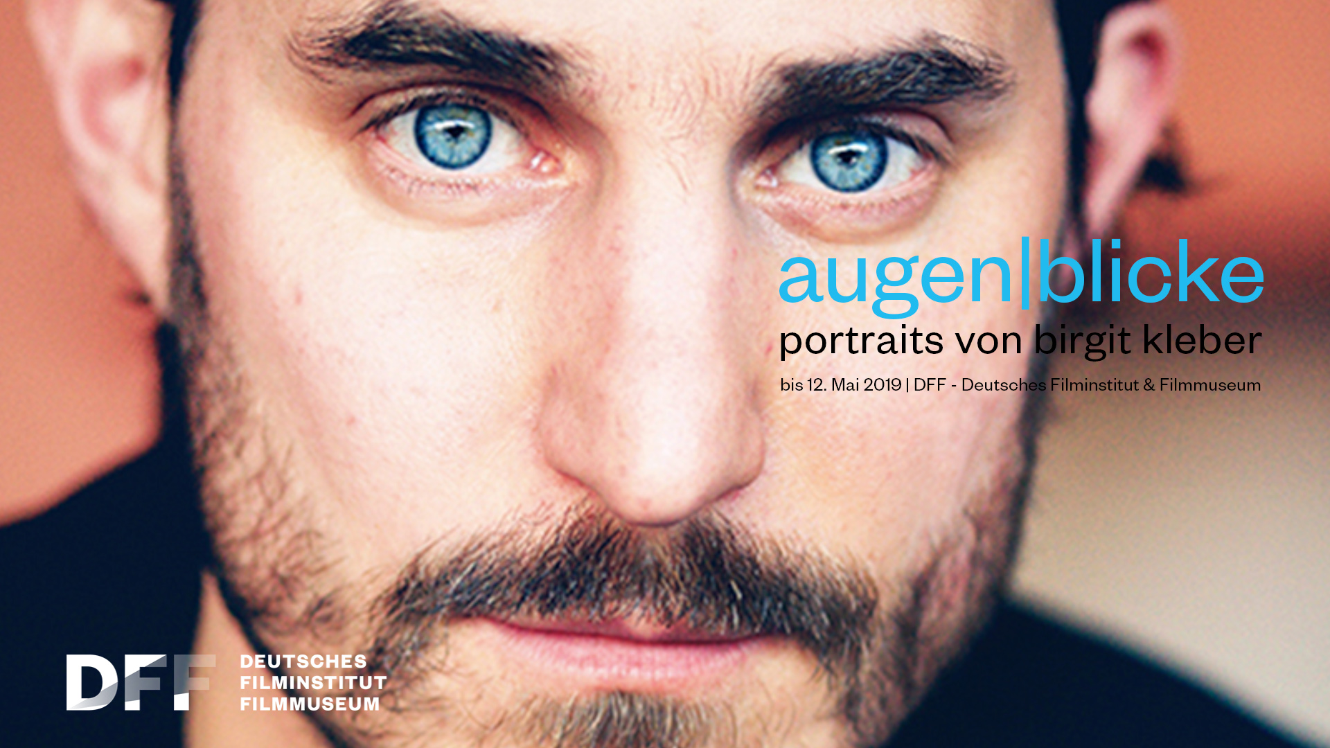 Ein weiteres Porträtplakat. Ein Mann mit stechend blauen Augen und Bart.