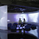 zwei Personen sitzen im zentralen Projektionsraum der Ausstellung IM TIEFENRAUSCH