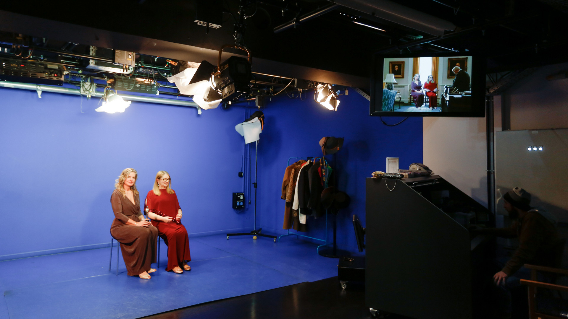 Zwei Frauen sitzen vor einem blauen Hintergrund im Filmstudio des DFF