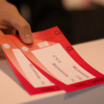 Zwei rote Tickets werden von jemanden über den Tresen gereicht.
