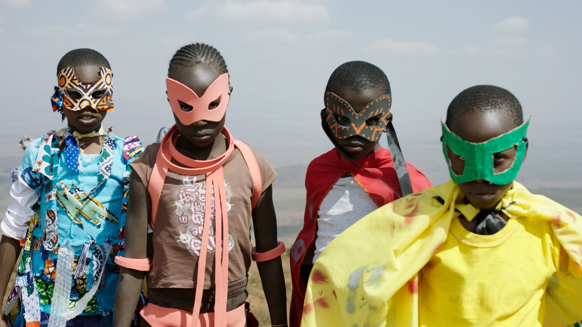 Filmstill aus SUPA MODO: Vier Kinder in bunten Superheldenkostümen