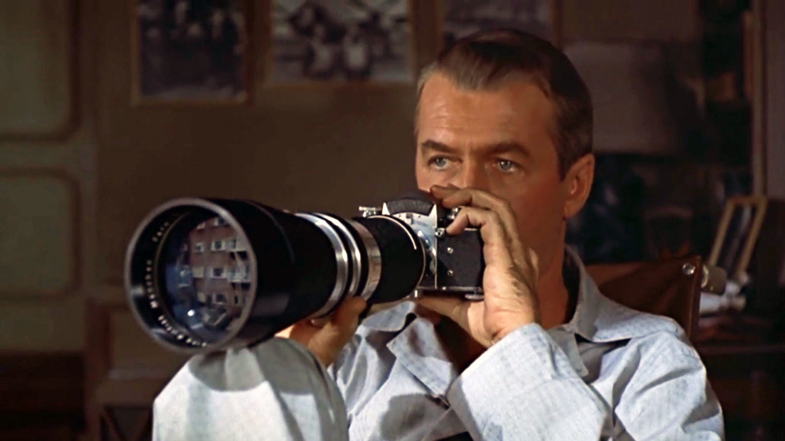 Filmstill aus Rear Window. Ein Mann hält eine Kamera, mit einem großen Objektiv daran, in Händen.