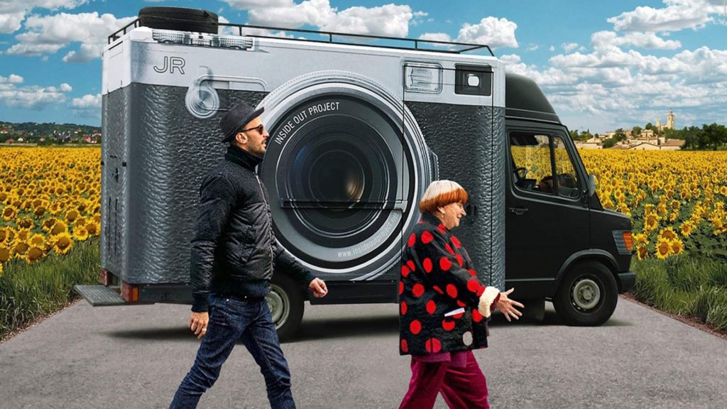 Filmstill Agnes Varda und Künstler JR vor einem Lieferwagen auf den eine große Kamera gedruckt ist