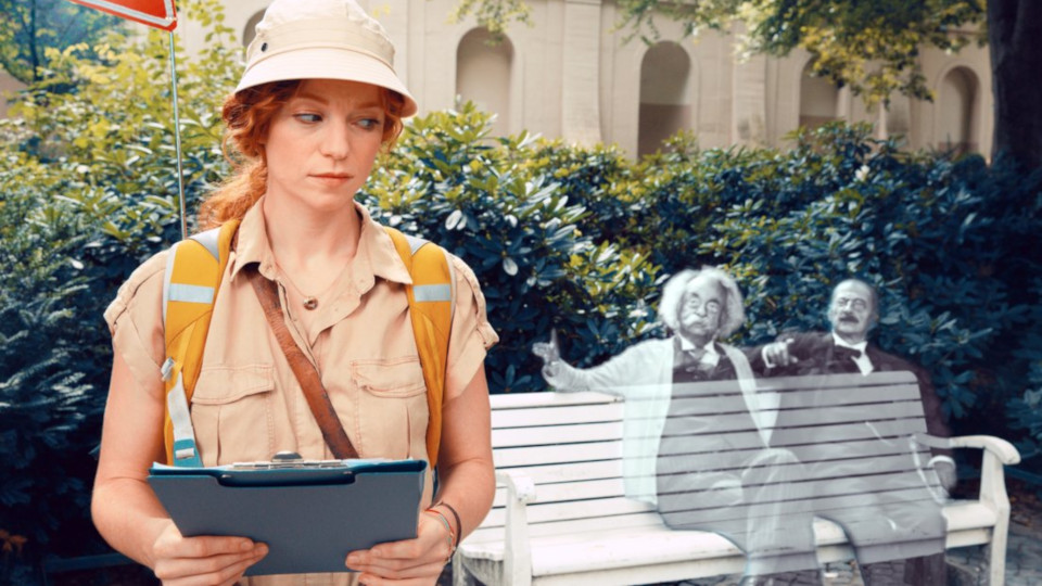 Darstellerin der Rolle Cleo steht vor einer Parkbank auf der unter anderem der Geist von Albert Einstein zu sitzen scheint.