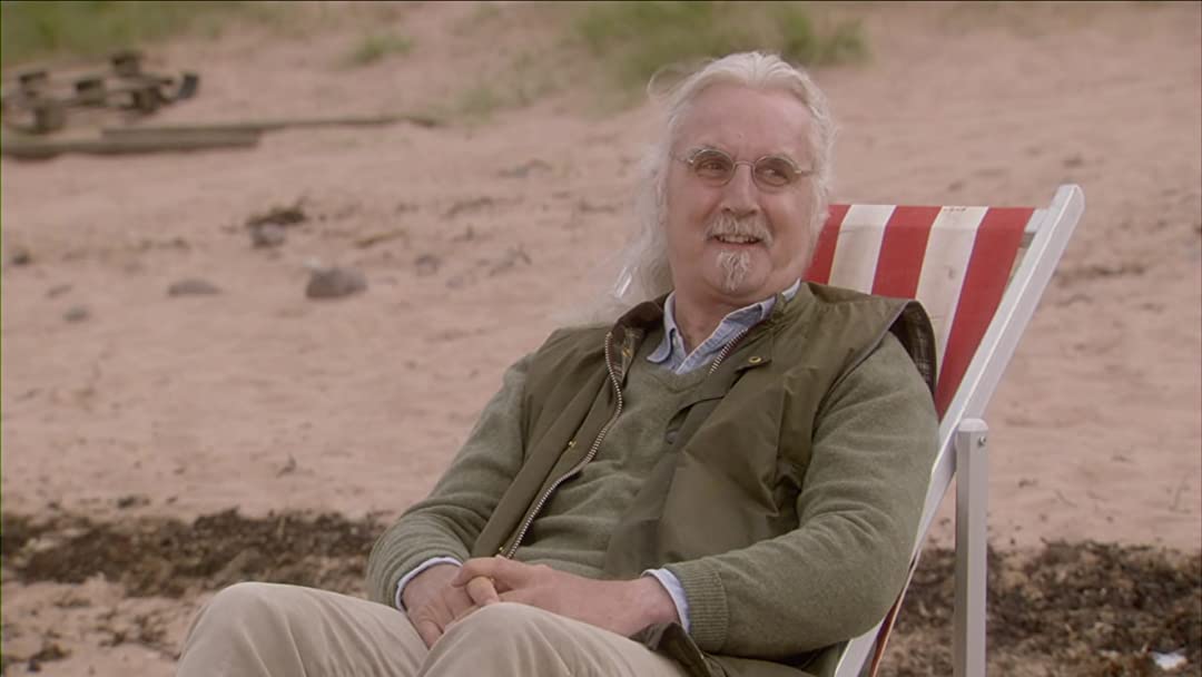 Billy Connolly in einem rot-weißen Strandstuhl am Strand in WHAT WE DID ON OUR HOLIDAYS