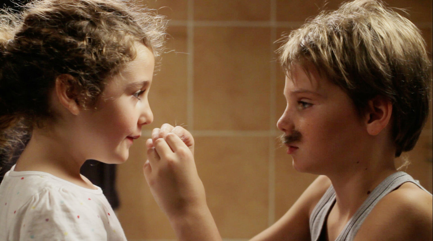 Filmstill Tomboy Zwei Kinder kleben sich Schnurrbärte auf