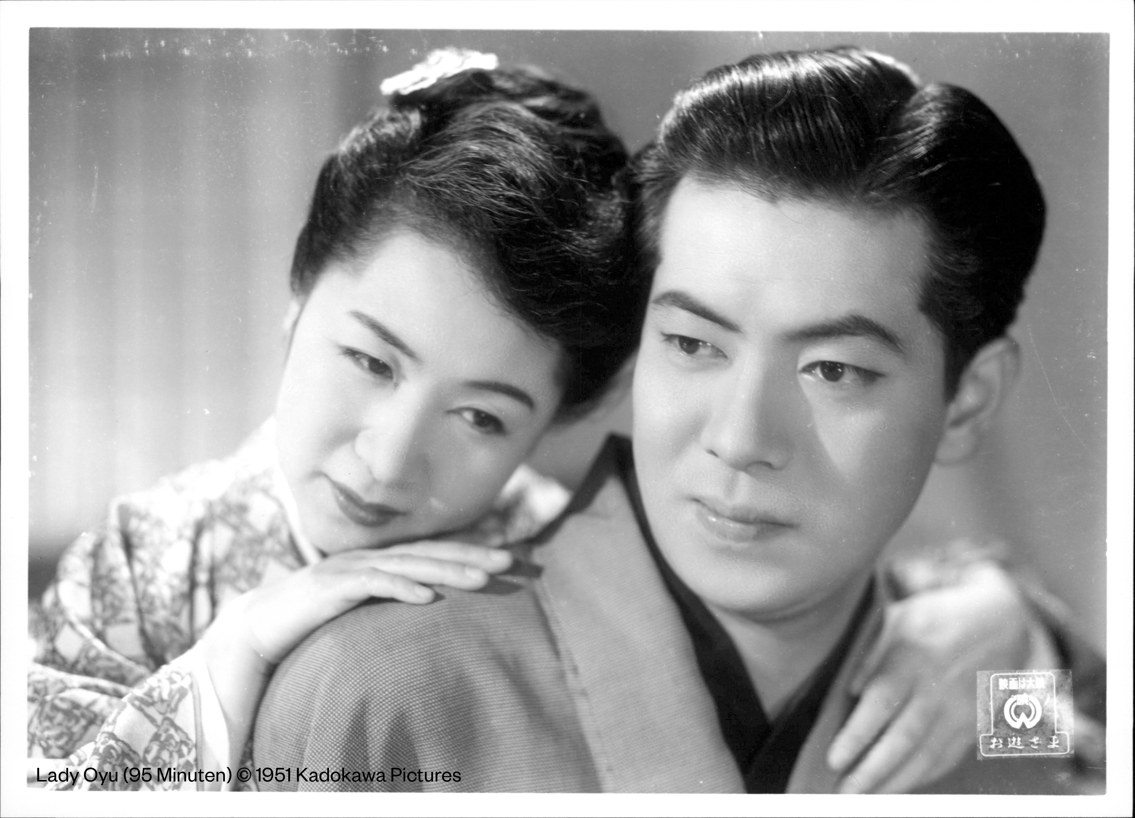 Die Schwarz-Weiß-Aufnahmen zeigt eine Frau und einen Mann, die beide in Kimonos gekleidet sind.