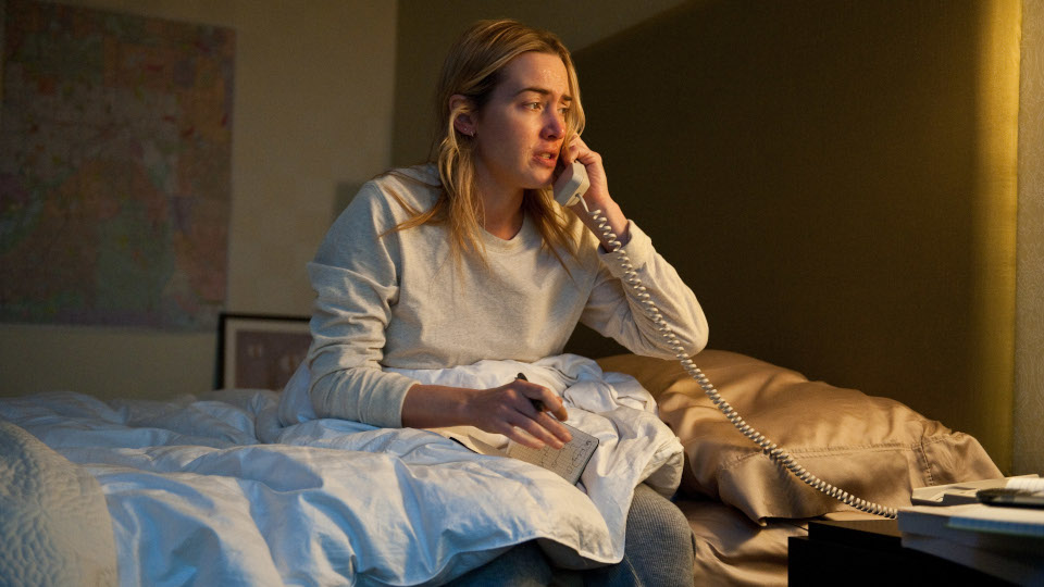 Filmstill aus Contagion. Eine junge Frau sitzt auf einem Bett und hält sich den Telefonhörer ans Ohr.