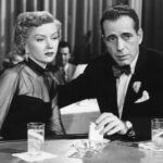 Schwarzweißbild aus "In a lonely Place" zeigt die beiden Hauptdarsteller schick gekleidet an einem Tisch sitzen
