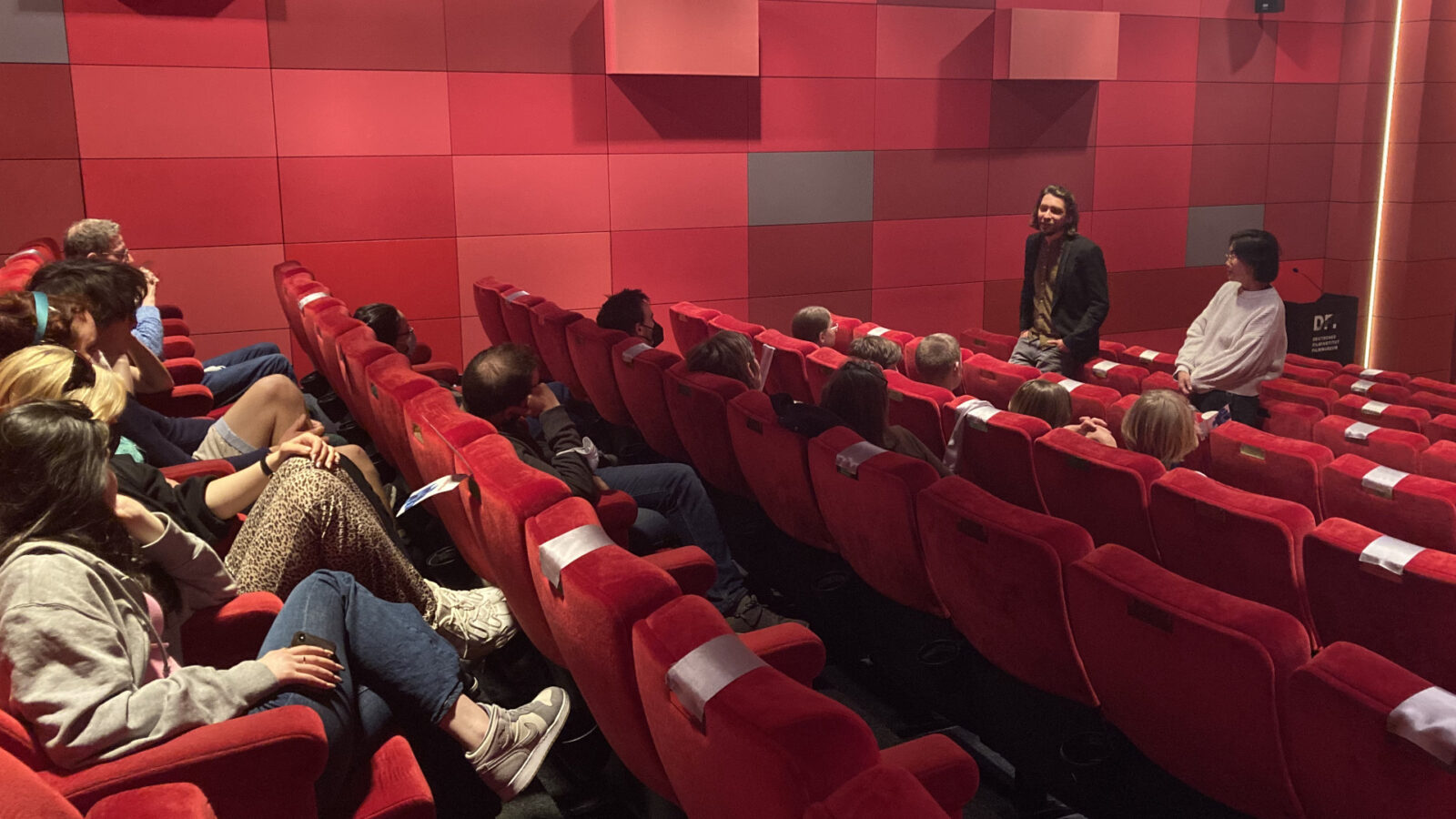 A guest talks to members of the Blickwechsel Jetzt film club at the DFF cinema.