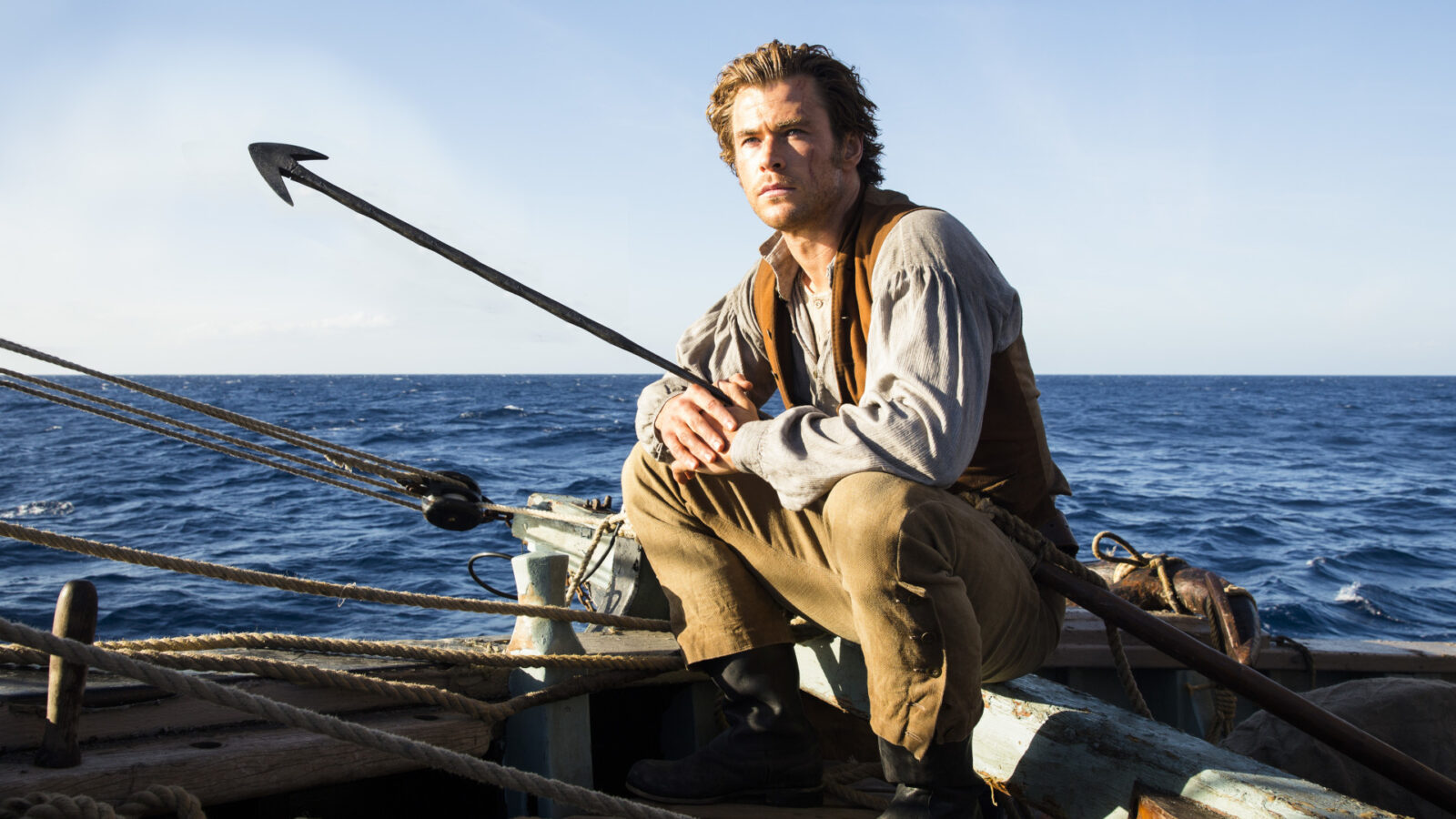 Filmstill aus Im Herzen der See: Mann sitzt auf einem Schiff, hinter ihm das Meer