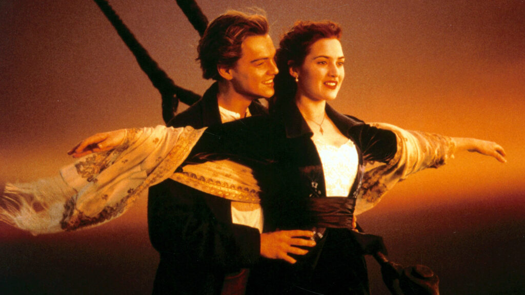 Leonardo DiCaprio und Kate Winslet am Bug der Titanic. Sie breitet die Arme aus.