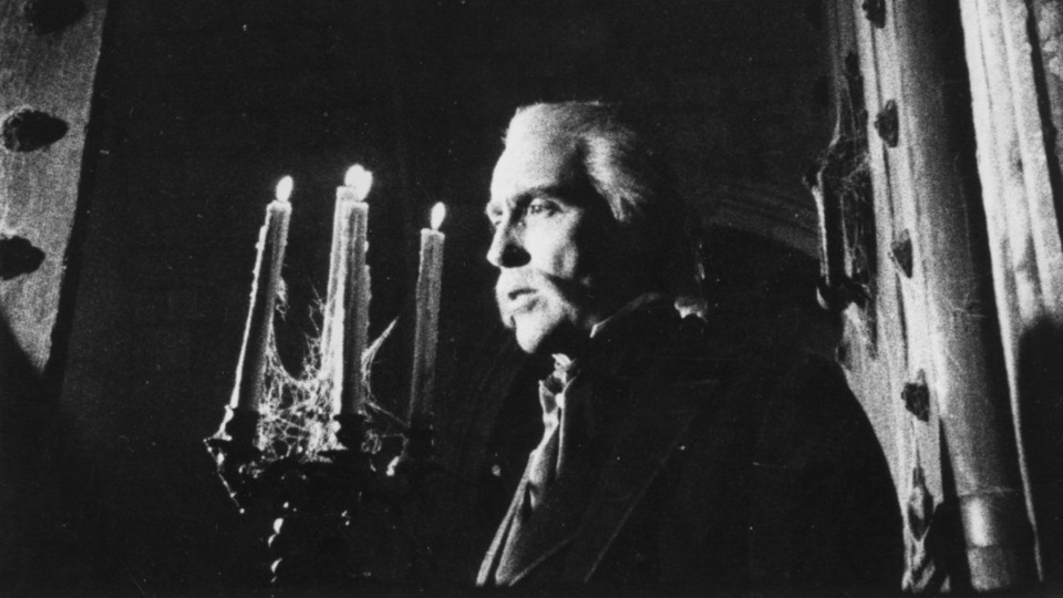 Schwarz-Weiß-Filmstill aus Cuadecuc Vampir: Ein Mann steht vor einem Kerzenständer