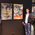 Drei Personen stehen neben den Filmplakaten von Ferry Ahrlé im Foyer des DFF