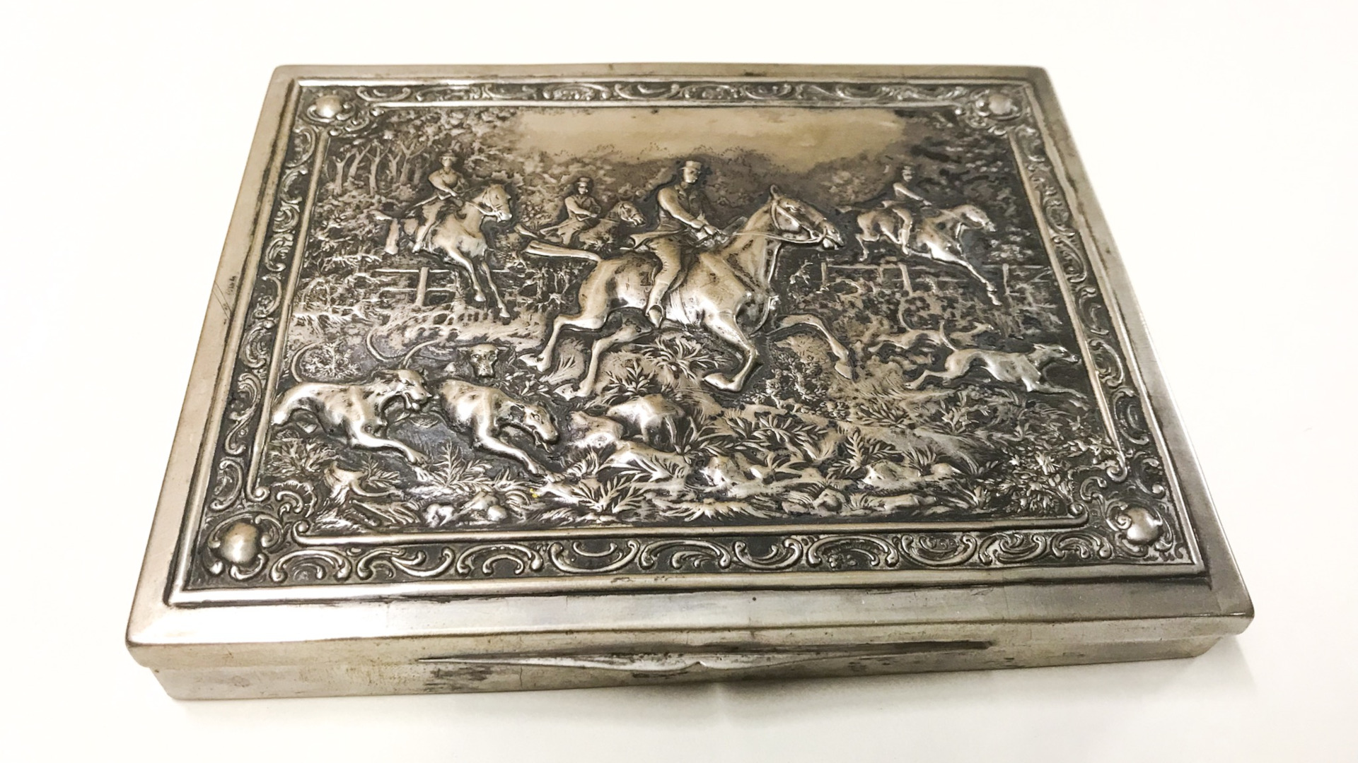 Eine silberne Dose mit einem Relief, das eine Jagdszene zeigt