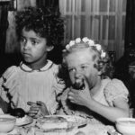 Vier Kinder sitzen an einem Tisch und essen Kuchen