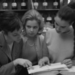 Drei Frauen Mitte der 1960 er Jahre in einer Apotheke über ein Buch gebeugt