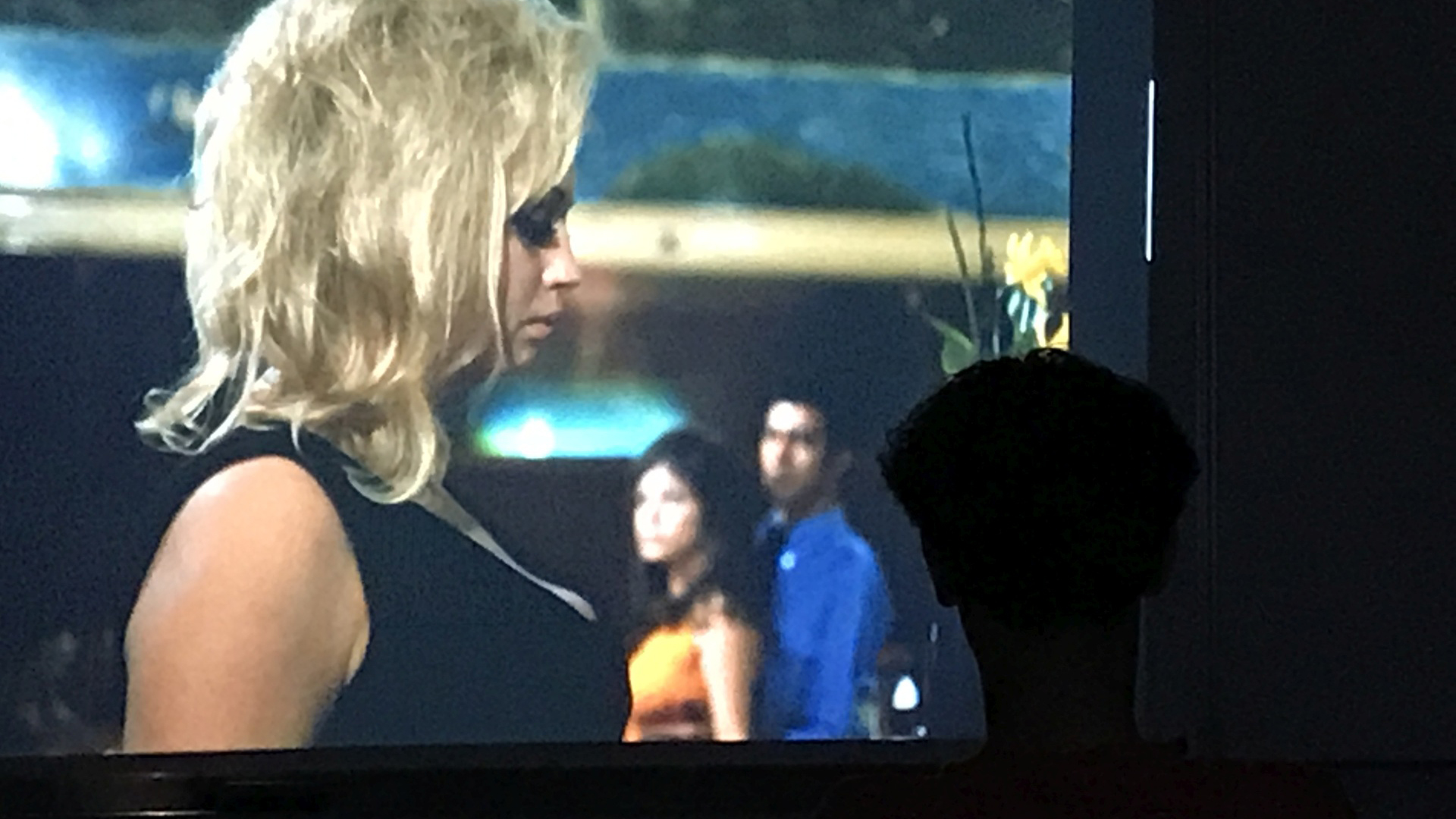 Silhouette eines Kopfes vor einer Leinwand. Auf der Leinwand steht eine Schauspielerin in Nahaufnahme im Bild