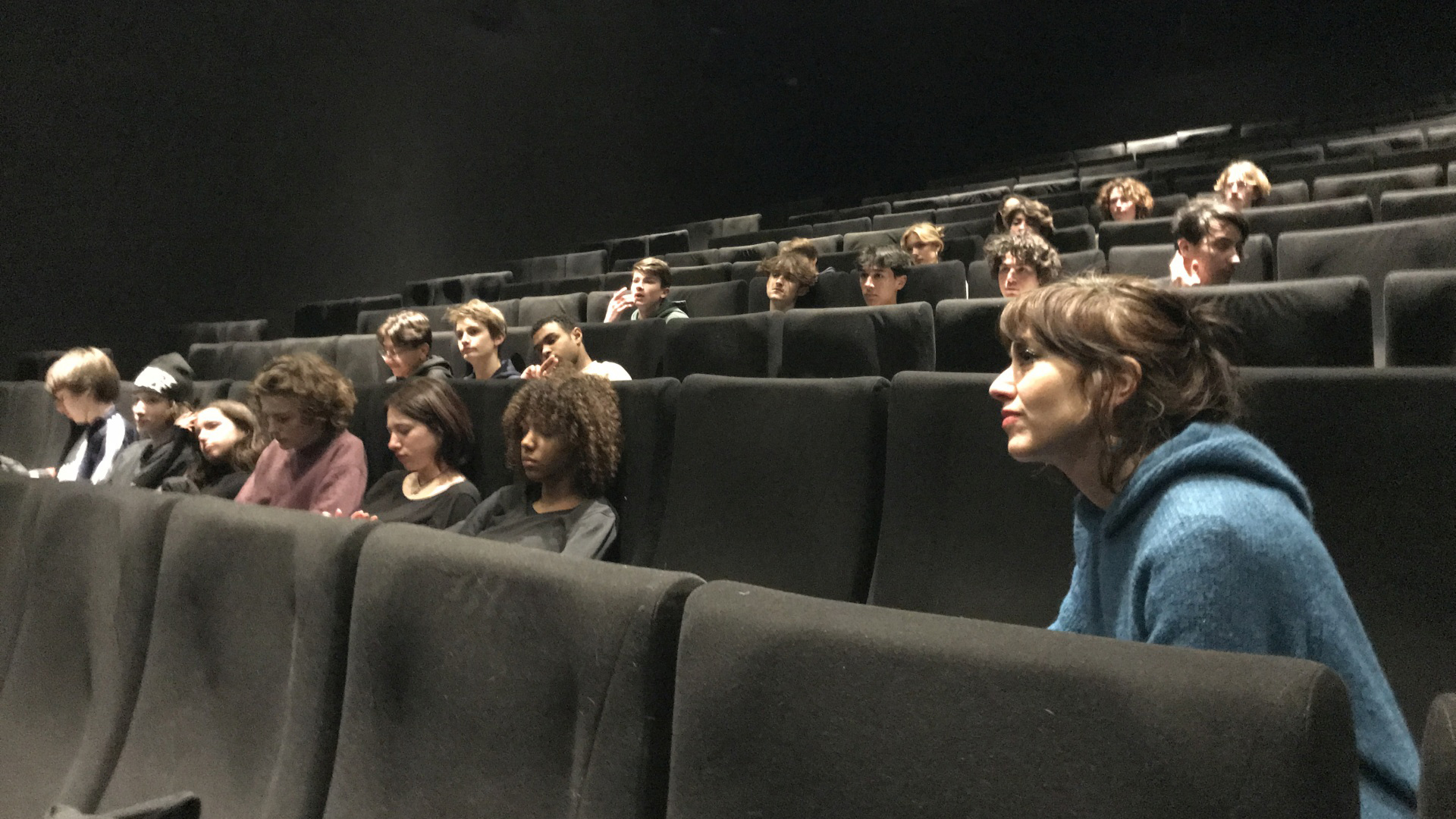 Eine Schulklasse sitzt in den Reihen eines Kinosaals