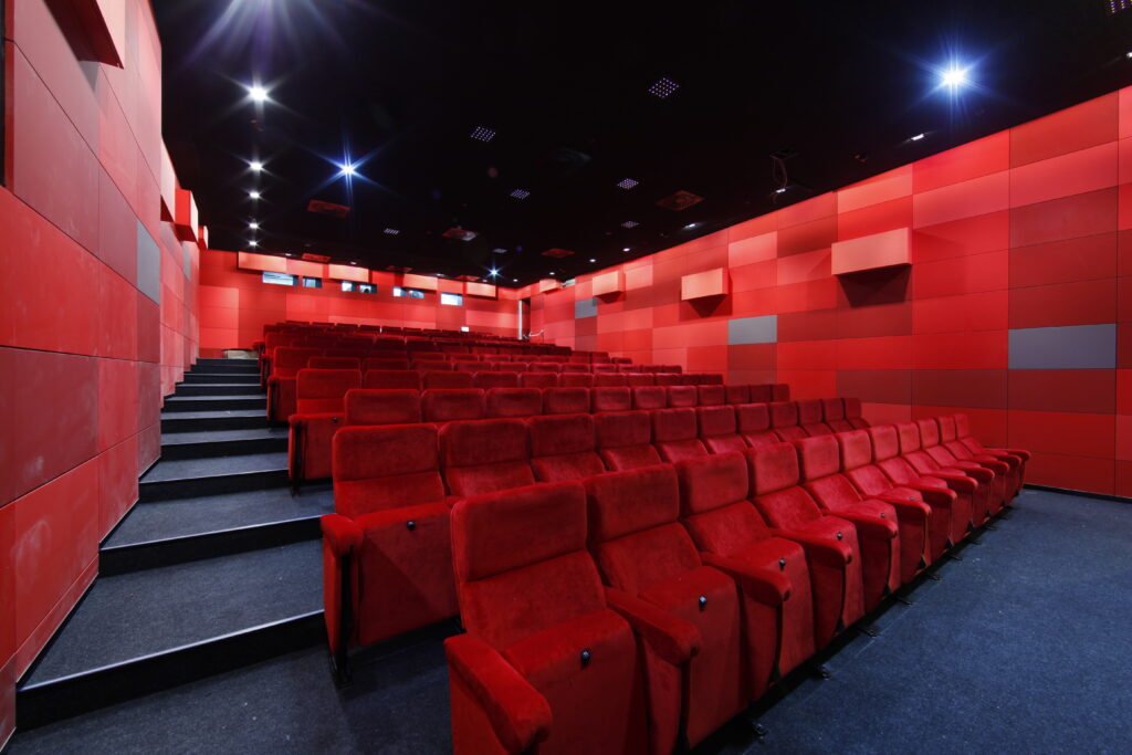 Ein leerer Kinosaal mit roten Samtsesseln und roter Vertäfelung